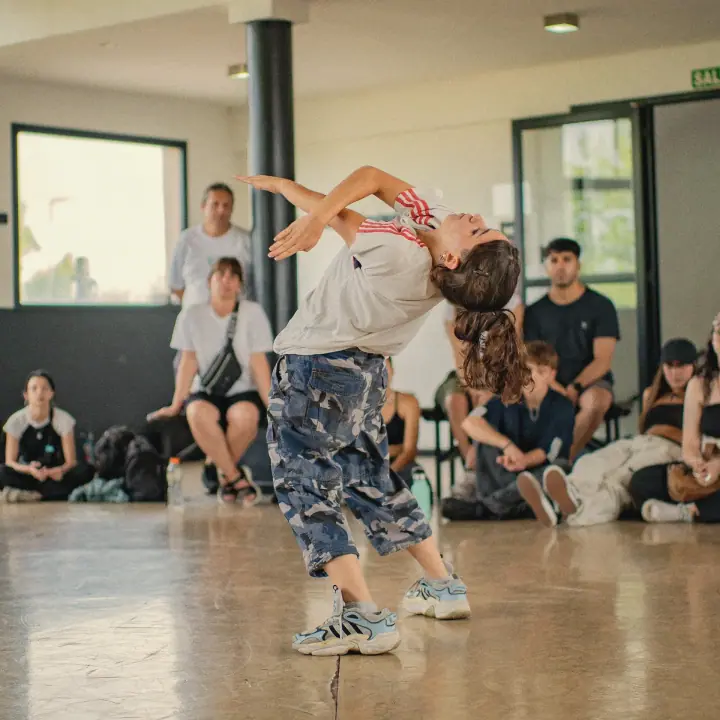 Una bailarina arquea la espalda en plena batalla, con el público alrededor